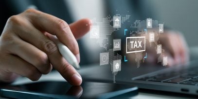 businessperson,using,digital,smartphone,and,laptop,to,manage,global,tax