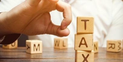 businessman,removes,wooden,blocks,with,the,word,tax.,the,concept
