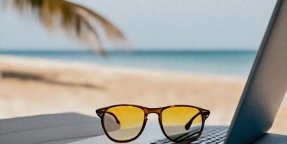 laptop,open,on,beach,bed,with,sunglasses